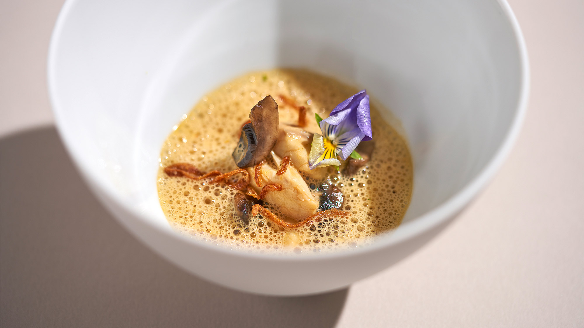 Fish amok with a flower in a white bowl.