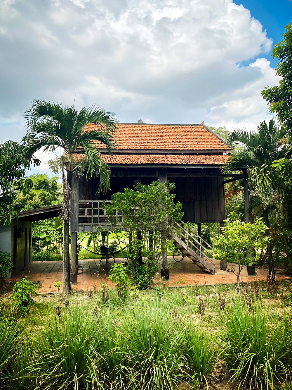 La maison d’une famille d’agriculteurs entourée d’arbres et de plantes.