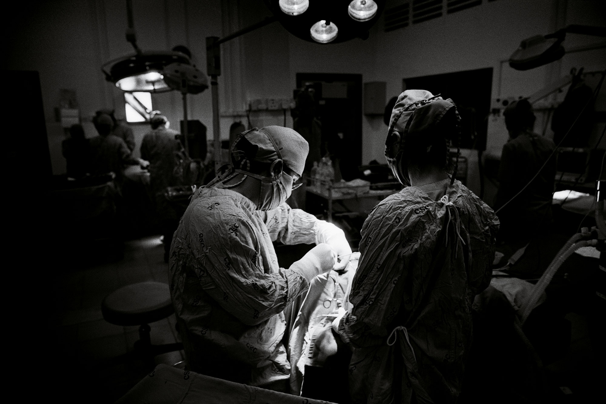 Black-and-white photograph of a medical team performing surgery.