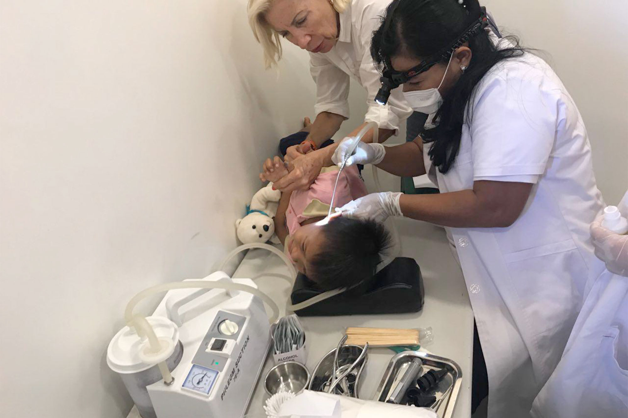 A dental team treats a child in a dental chair.