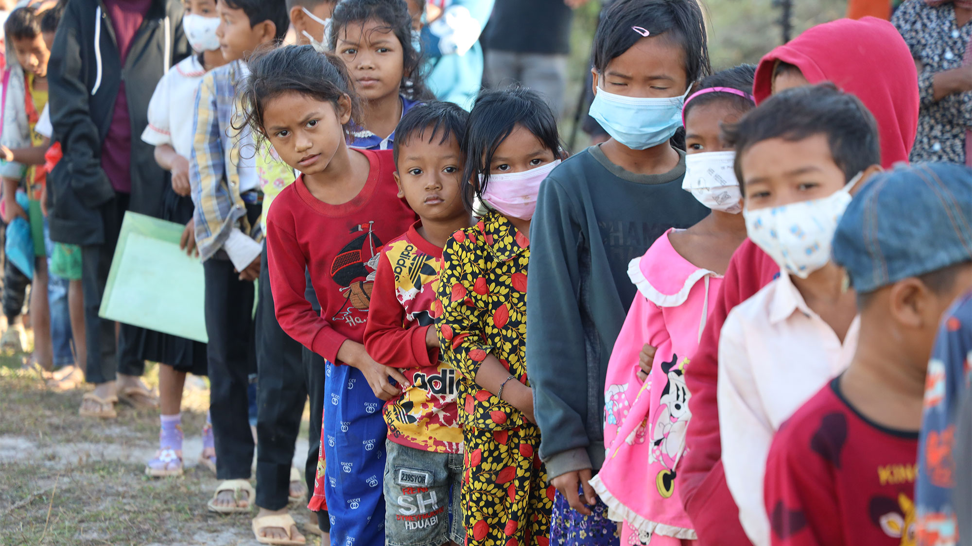 Des enfants font la queue pour recevoir des produits de première nécessité.
