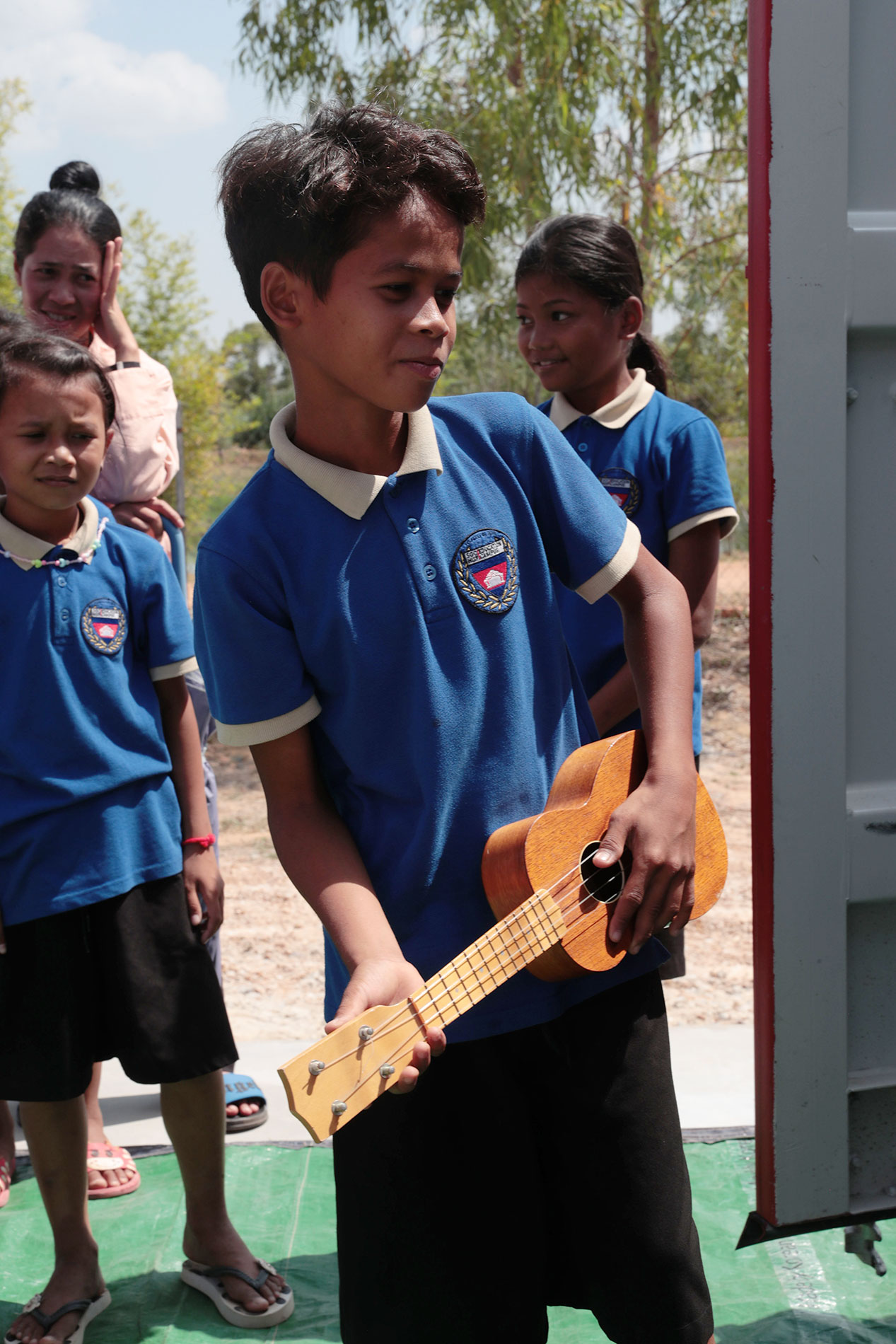 Ein Schulkind hält eine Gitarre bei der Instrumentenübergabe.