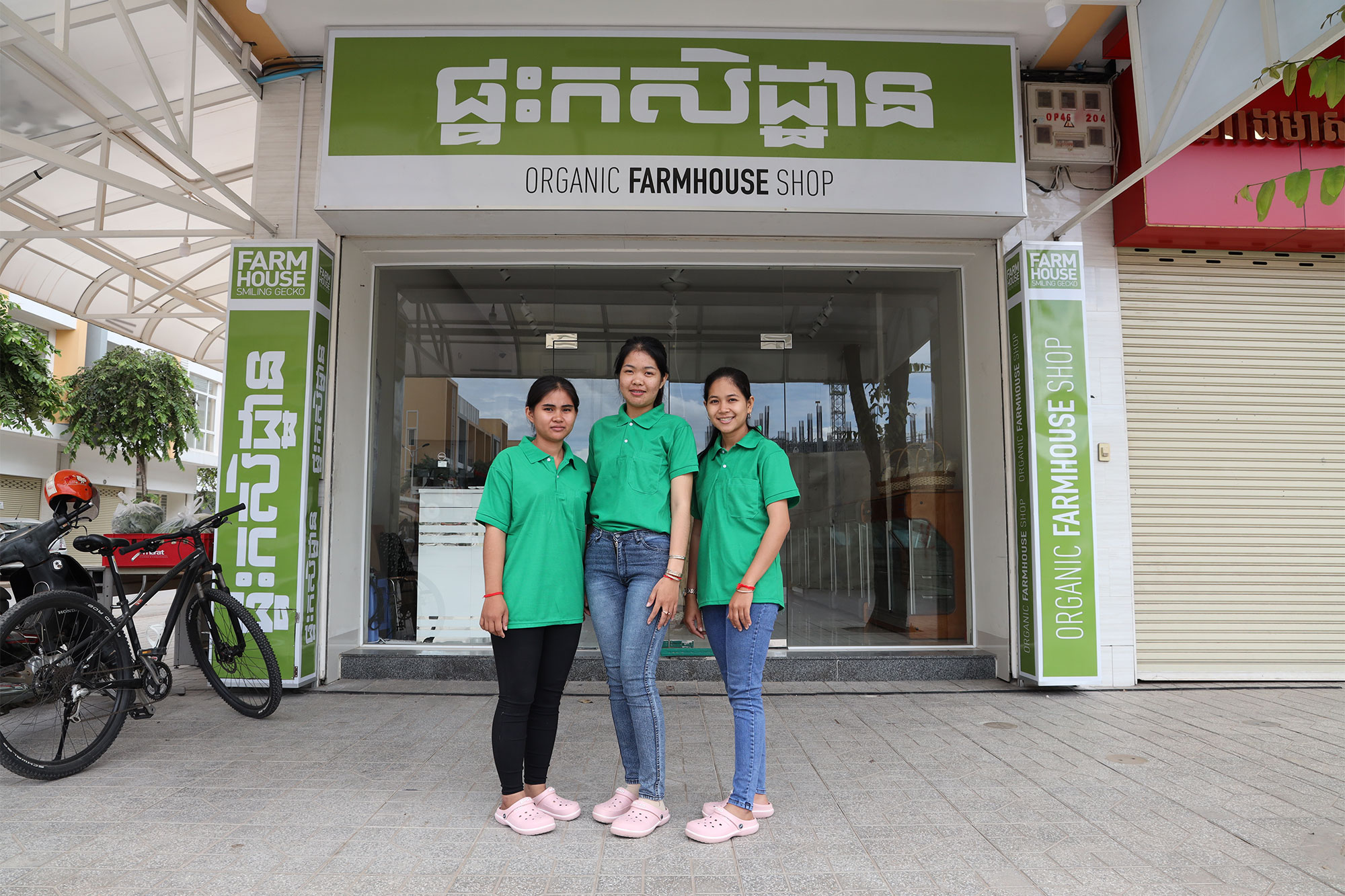 Trois employées se tiennent devant l’entrée de l’Organic Farmhouse Shop.