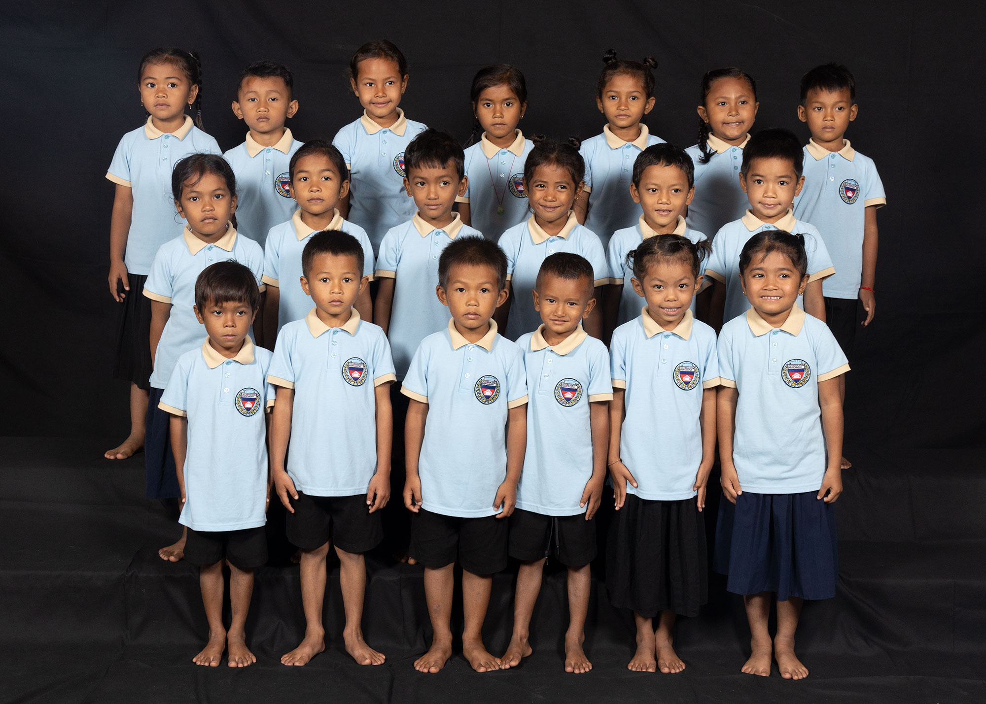 Group portrait of children in light blue school uniforms.