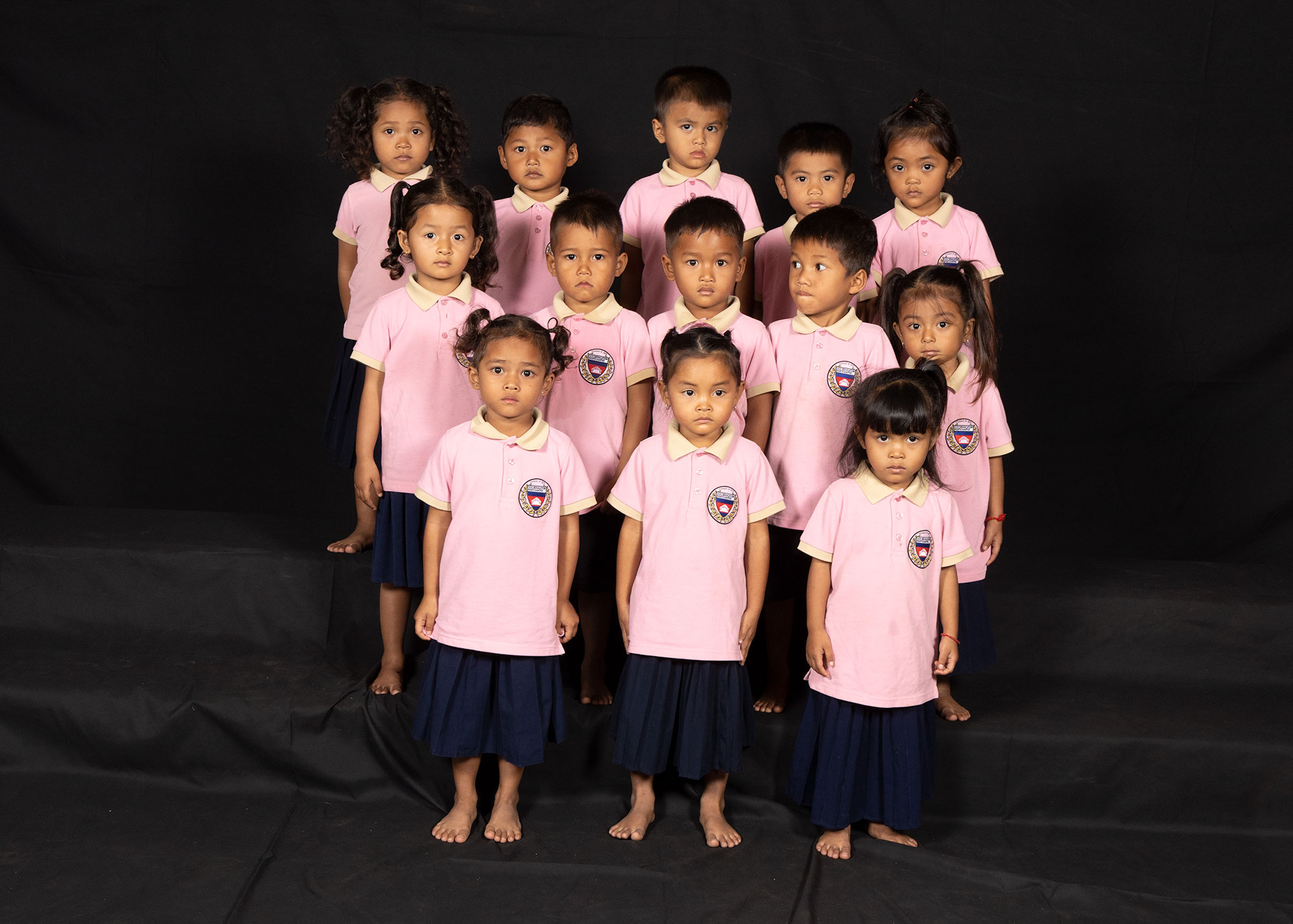 Group portrait of children in pink school uniforms.