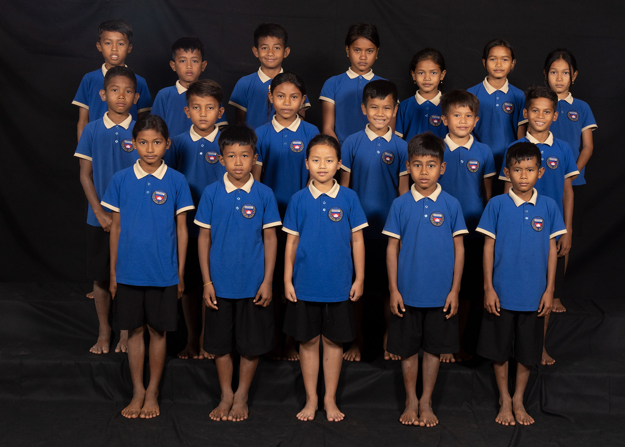 Group portrait of children in dark blue school uniforms.