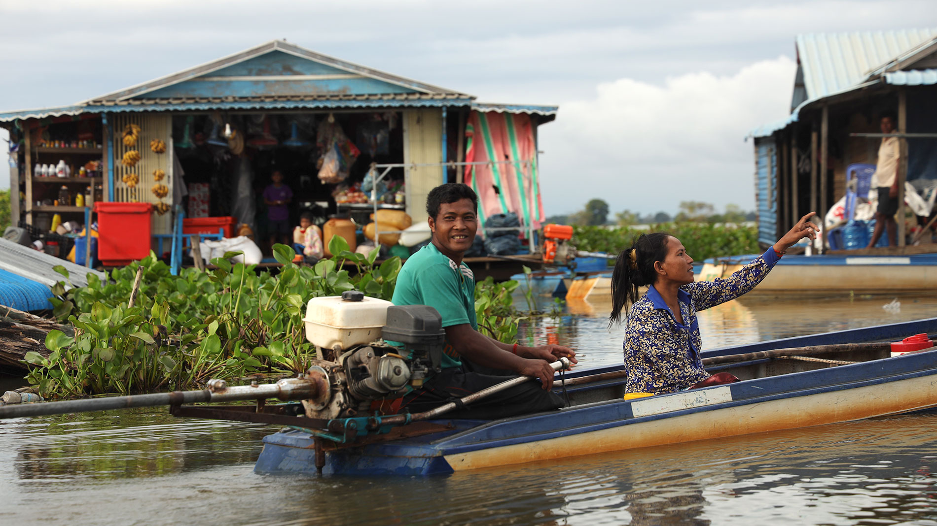 People in a boat among flooded houses.