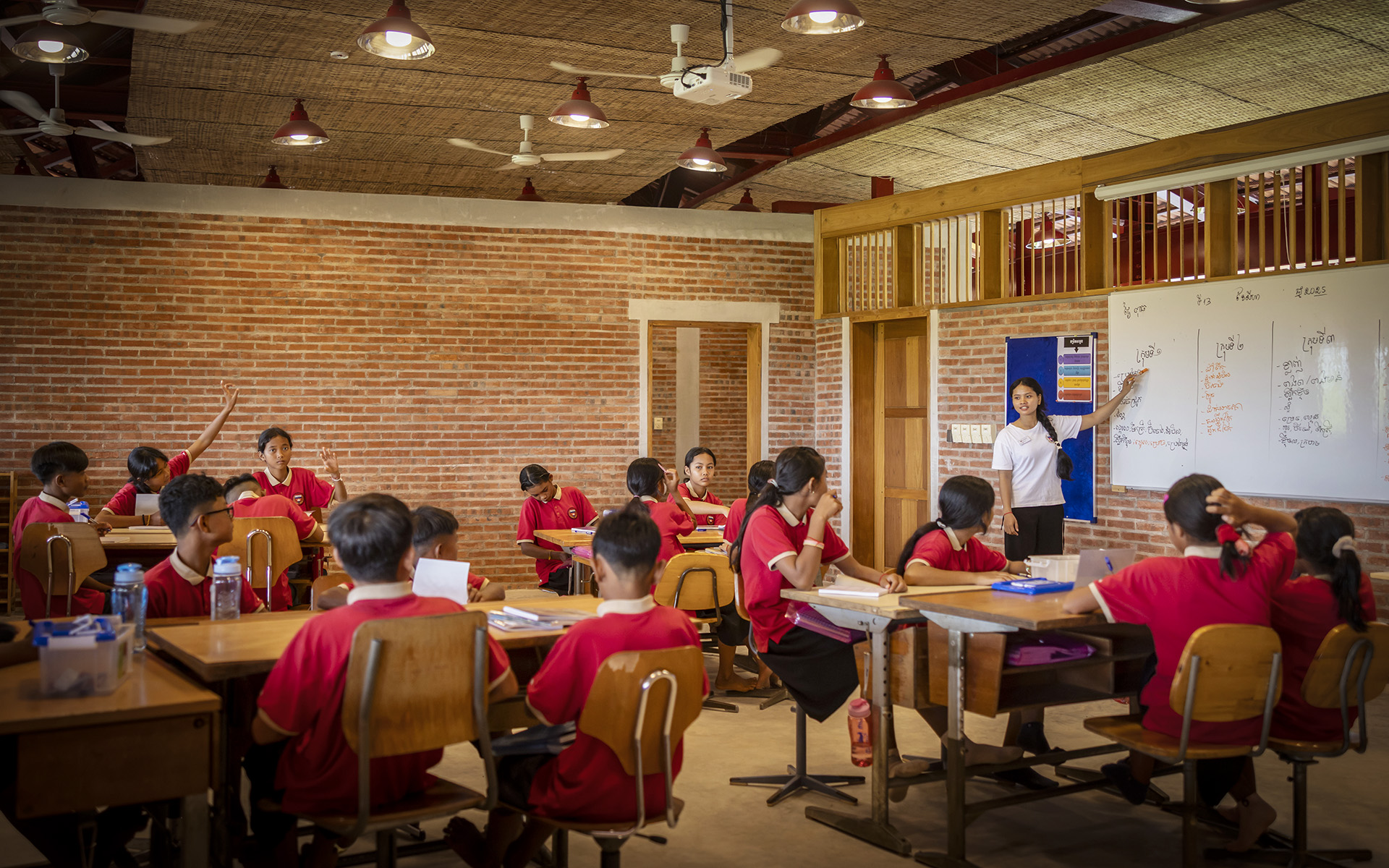 Lesson in the new classroom with children wearing red school shirts.