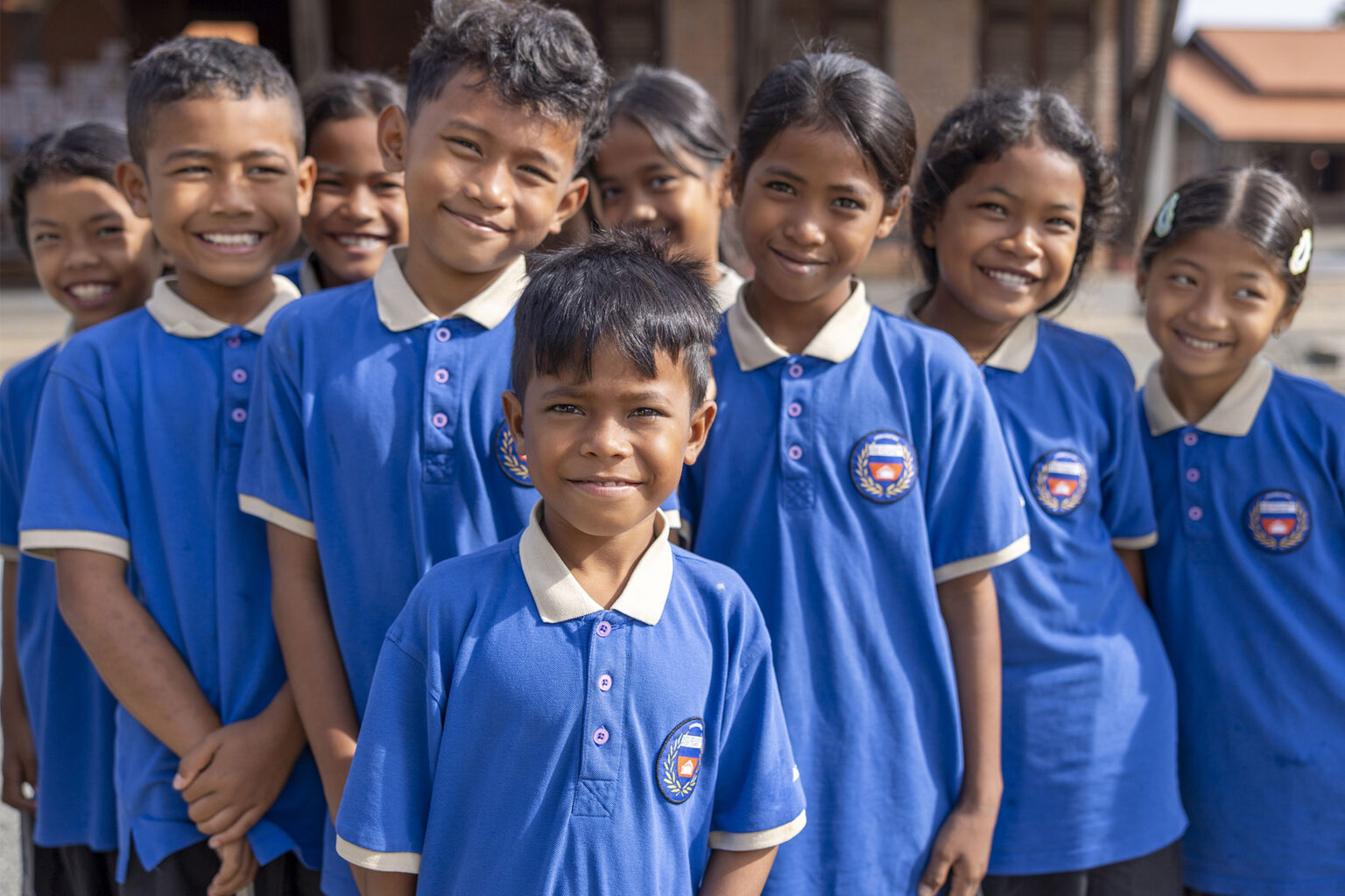 Un groupe d’élèves en polos scolaires bleus.