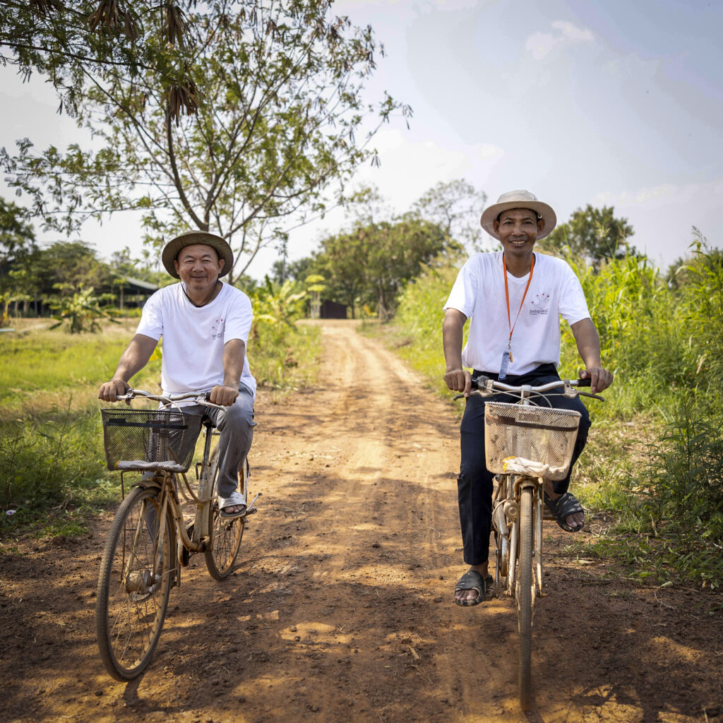 Two trainees with bicycles on a path.