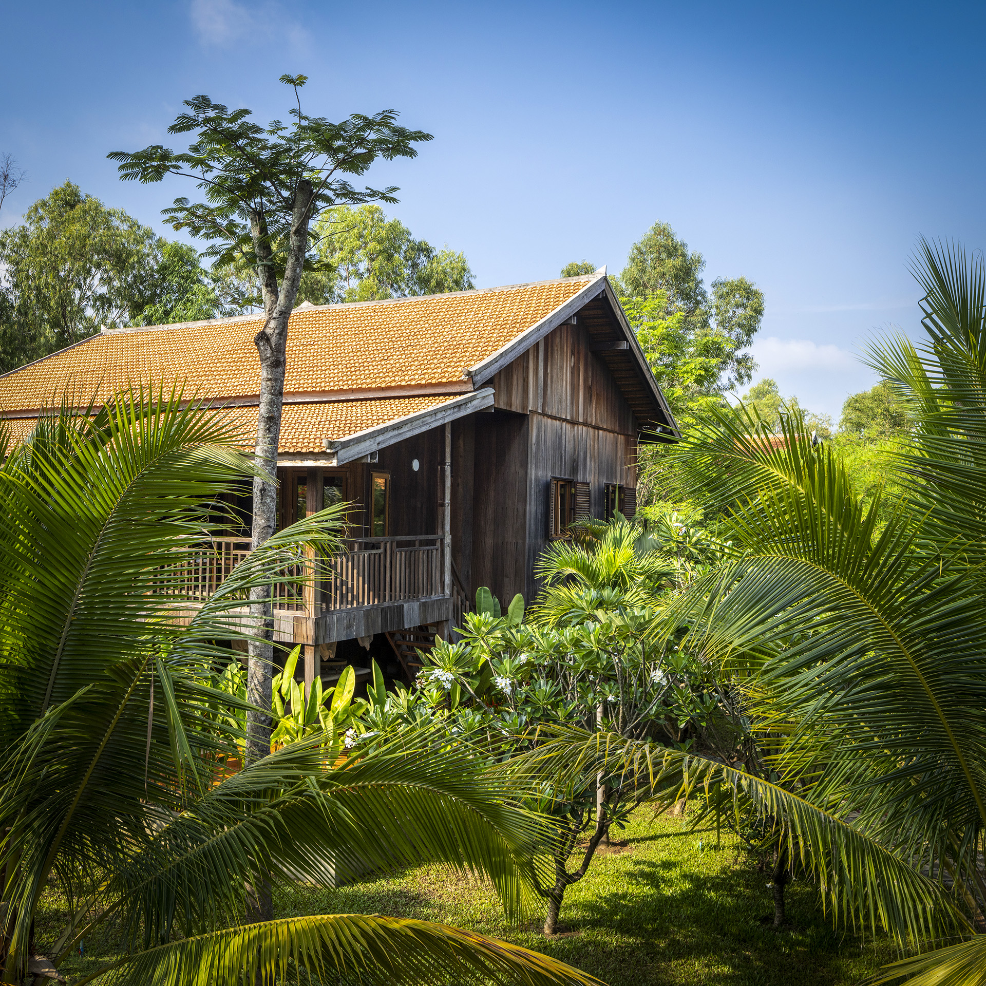 Holzbungalow im tropischen Garten des Farmhouse Resorts.